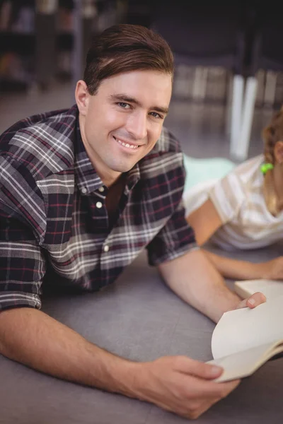 Glad lärare läsa boken i biblioteket — Stockfoto