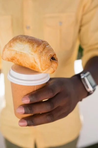 Man håller kaffekoppen och bröd — Stockfoto