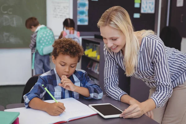 Enseignant aidant écolier avec ses devoirs — Photo