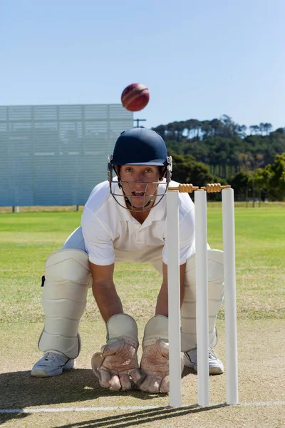 Wicketkeeper olhando para bola no campo — Fotografia de Stock