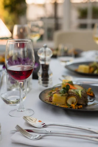 Rode wijn met voedsel geserveerd op tafel — Stockfoto