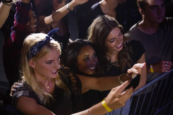 Friends watching and taking photograph of performer — Stock Photo, Image