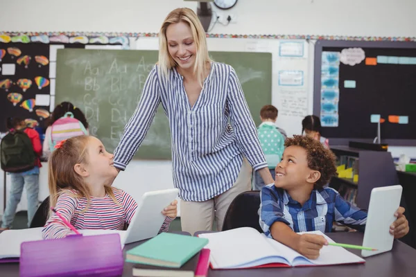 Tanár segíti a házi feladat schoolkids — Stock Fotó