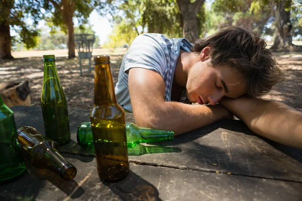 Пьяный мужчина спит на столе в парке — стоковое фото