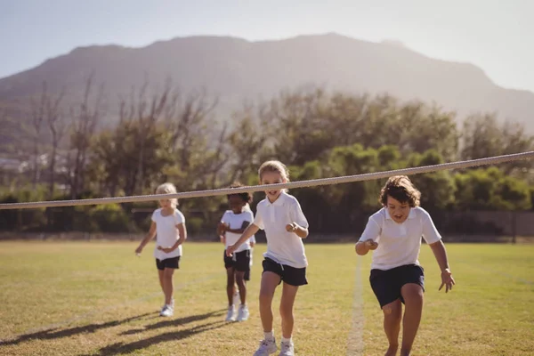 Schoolmeisjes uitgevoerd naar afwerking lijn — Stockfoto