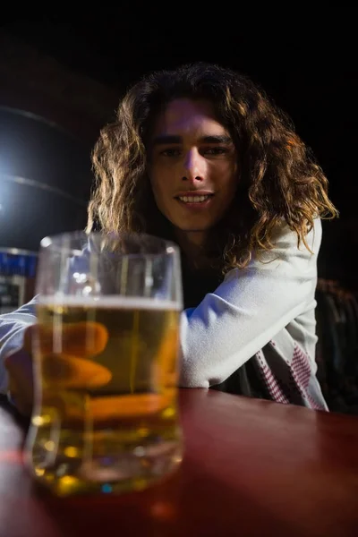 Hombre sosteniendo taza de cerveza en el bar — Foto de Stock