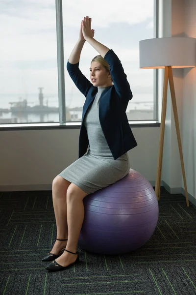 Executivo meditando sobre bola de fitness — Fotografia de Stock