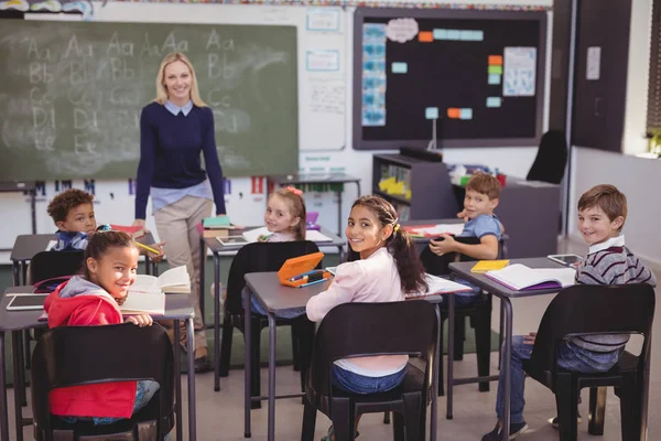 Teacher and schoolkids in classroom — Stock Photo, Image