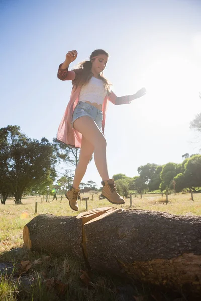 Mulher andando em um tronco de árvore — Fotografia de Stock