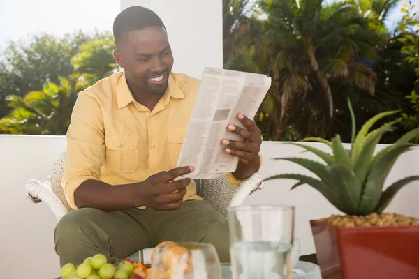 Hombre leyendo el periódico en la cafetería — Foto de Stock