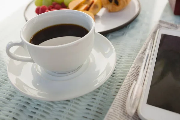 Taza de café por tableta digital en la mesa —  Fotos de Stock