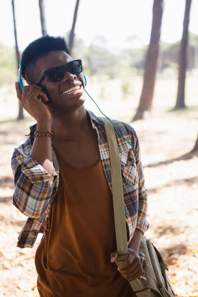 Uomo con occhiali da sole e cuffie che ascolta musica — Foto Stock