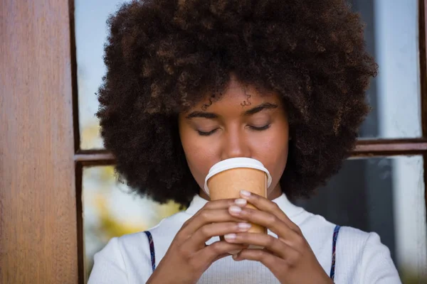 Frau trinkt Kaffee gegen Tür — Stockfoto