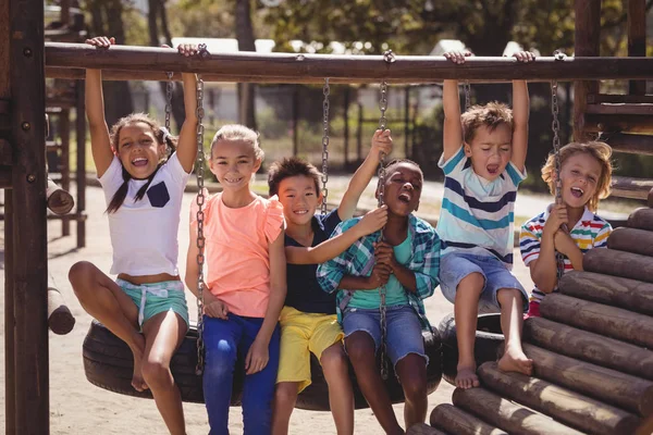 Schoolkids ha kul på däcket swing — Stockfoto