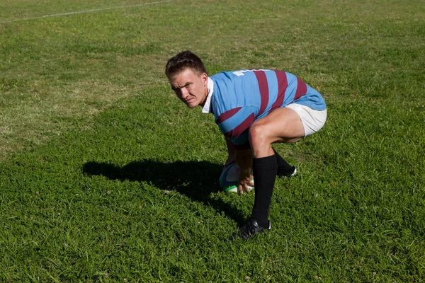 Rugbyspeler crouching op veld — Stockfoto