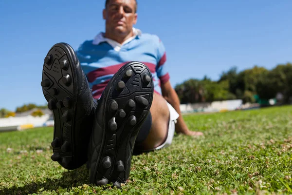 Rugby player sitting on field — Stock Photo, Image