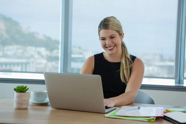 Femme exécutive utilisant un ordinateur portable au bureau — Photo