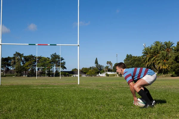 Jogador de rugby agachado em campo — Fotografia de Stock