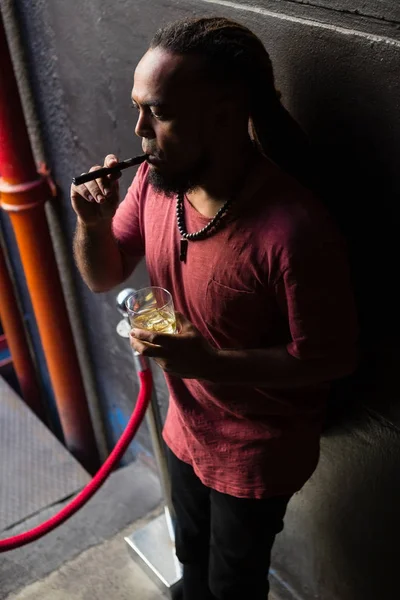 Hombre fumando cigarrillo electrónico en la entrada — Foto de Stock