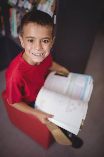 Schooljongen lezing boek in bibliotheek — Stockfoto
