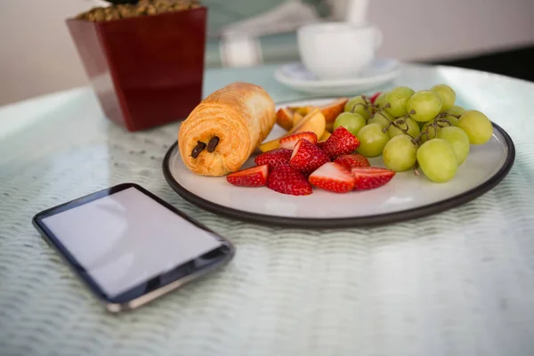 Telefone celular por frutas na mesa — Fotografia de Stock