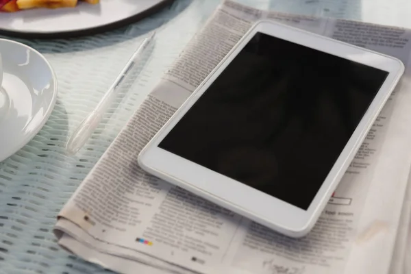 Tablet com jornal na mesa no café — Fotografia de Stock