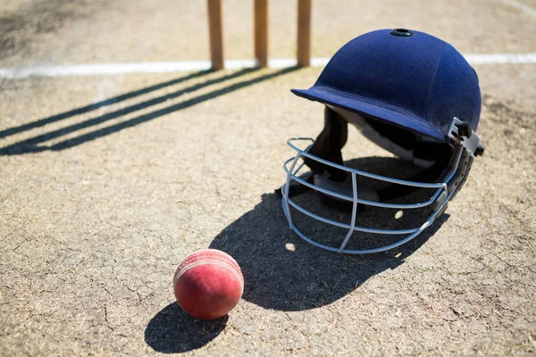 Cricket-Ball mit Helm auf dem Spielfeld — Stockfoto