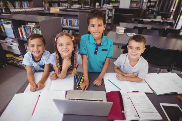 Schoolkinderen met laptop in de bibliotheek — Stockfoto