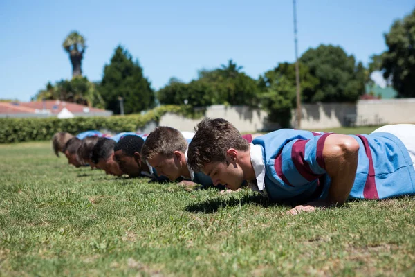 Rugbyspelers doen push up — Stockfoto