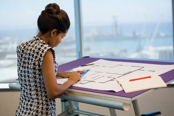 Arquitecta femenina trabajando en el plano — Foto de Stock