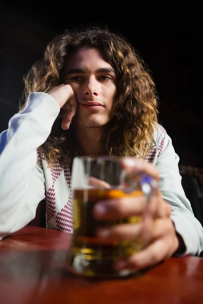 Человек держит кружку пива в баре — стоковое фото