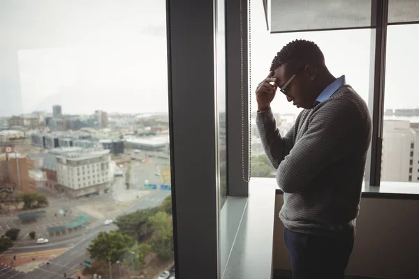 Spänd executive stående nära fönster — Stockfoto