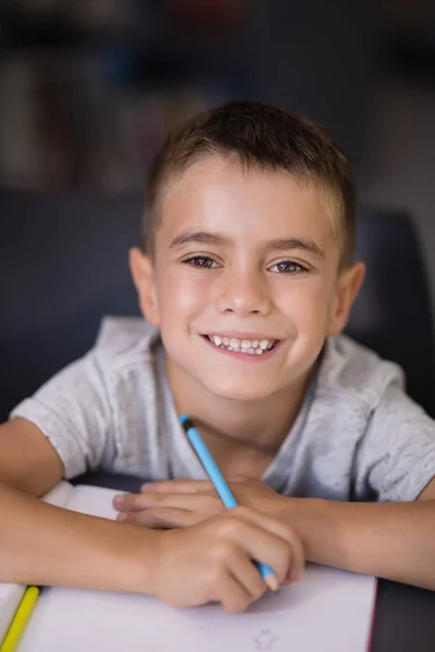 Schoolboy doing his homework in library — Stock Photo, Image