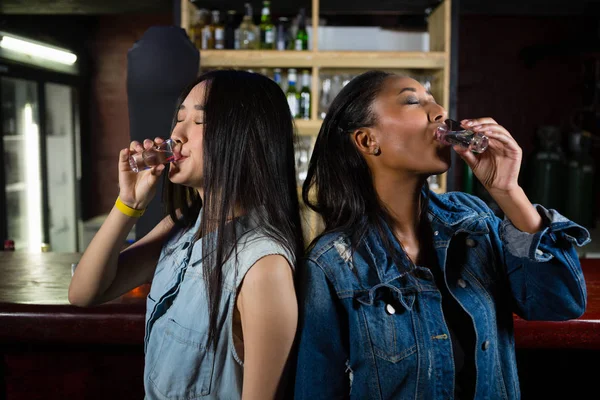 Female friends having tequila shot — Stock Photo, Image