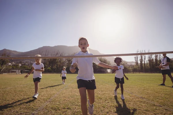 Schoolgirls running toward finishing line