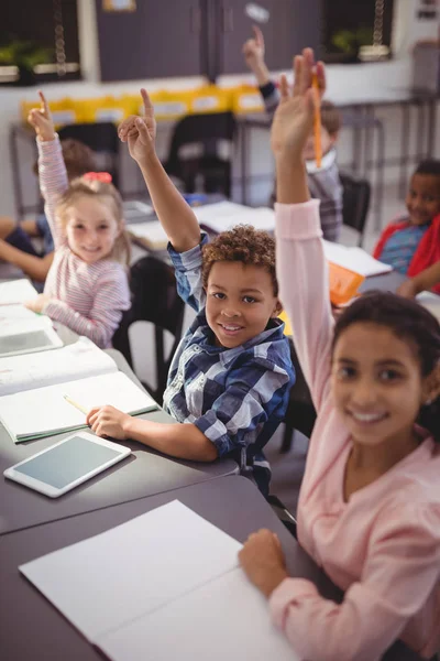 Schoolkids höja sina händer — Stockfoto