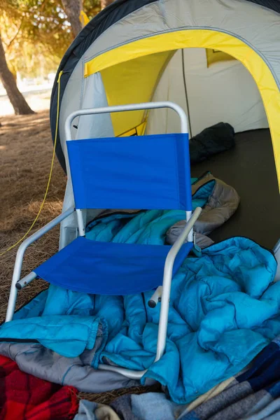 Stuhl und verschiedene Decken mit Zelt — Stockfoto