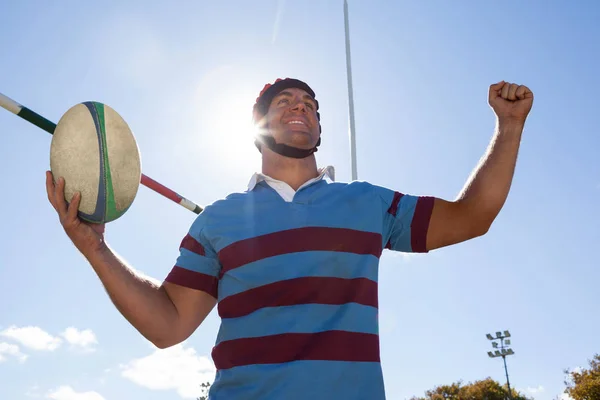 Jugador feliz sosteniendo pelota de rugby — Foto de Stock