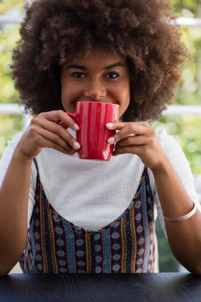Mulher com cabelos crespos tomando café no café — Fotografia de Stock