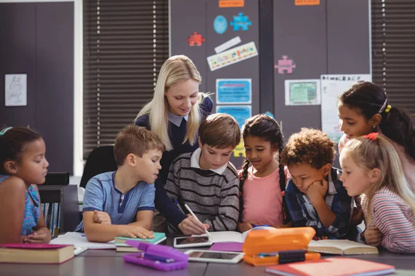 Leraar schoolmeisje helpen met haar huiswerk — Stockfoto