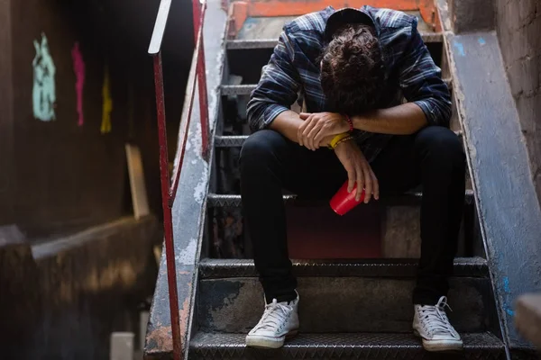 Drunk man sitting on staircase — Stock Photo, Image