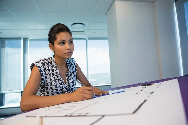 Arquitecta femenina trabajando en el plano — Foto de Stock