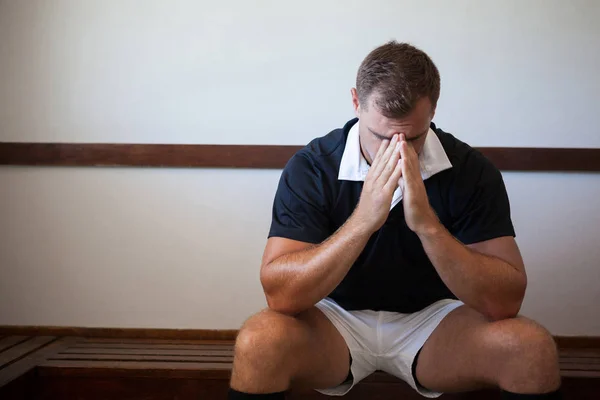 Rugby player sitting on bench — Stock Photo, Image