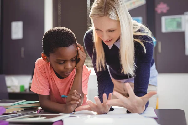 Professeur aidant écolière avec ses devoirs — Photo