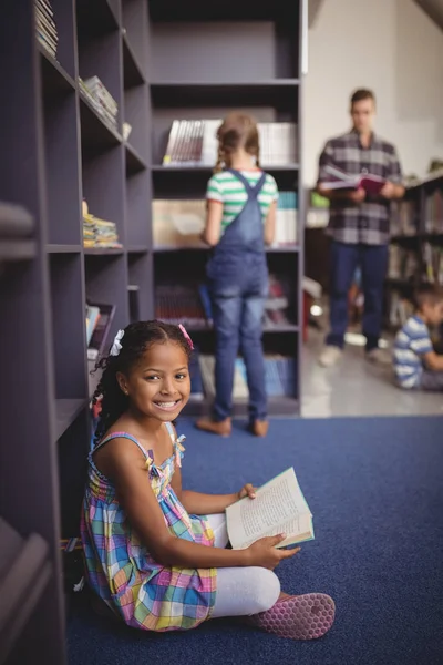 Schülerin liest Buch in Bibliothek — Stockfoto