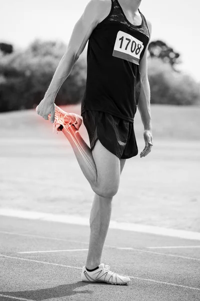 Athlet Mann dehnt sich auf Rennstrecke — Stockfoto
