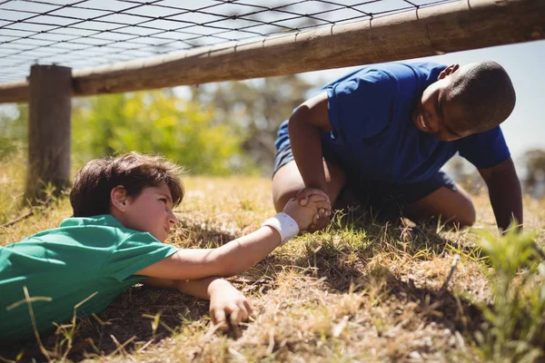 Jongen vriend helpt tijdens hindernissenparcours — Stockfoto