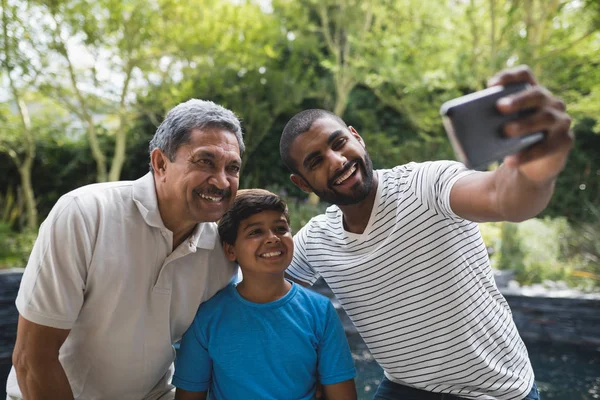 Família multi-geração tirando selfie no parque — Fotografia de Stock