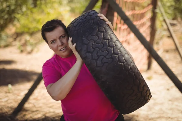 Mulher exercitando com pneu enorme — Fotografia de Stock
