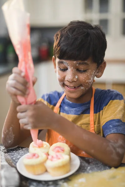 Ragazzo che fa torte tazza in cucina — Foto Stock